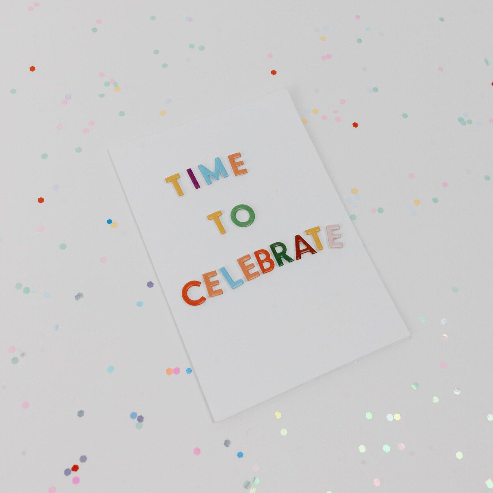 Vibrant 'Time to Celebrate' greeting card surrounded by confetti.